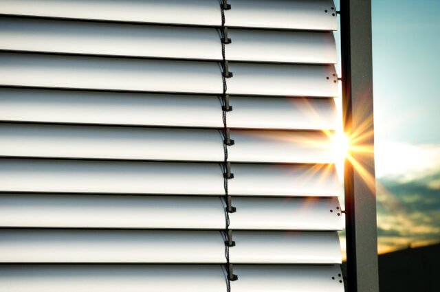Schutz vor Sommerhitze - Aussenjalousie mit Sonnenstrahlen